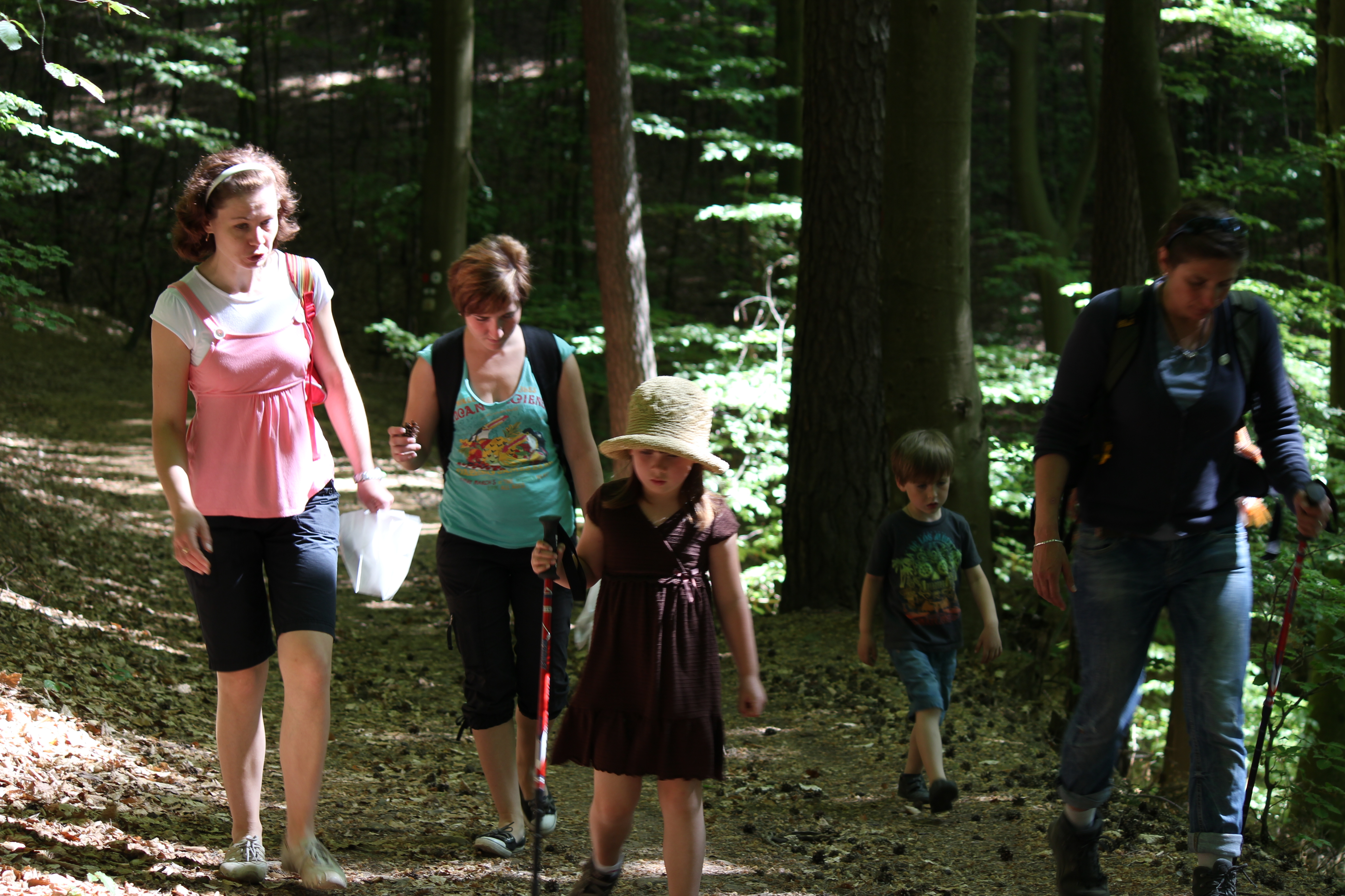 Familienwandern Drei Frauen mit zwei Kindern auf einem Wanderweg.