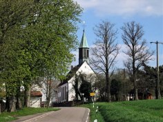 Weiße Kirche mit dunklem Dach und hellgrünem Kirchturm am Ortseingang Gerhardsbrunn.