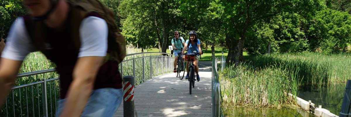 Drei Radfahrer, die über eine Brücke fahren
