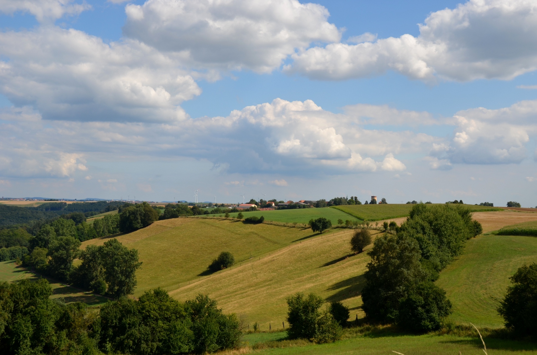 Hügellandschaft mit Dorf im Hintergrung